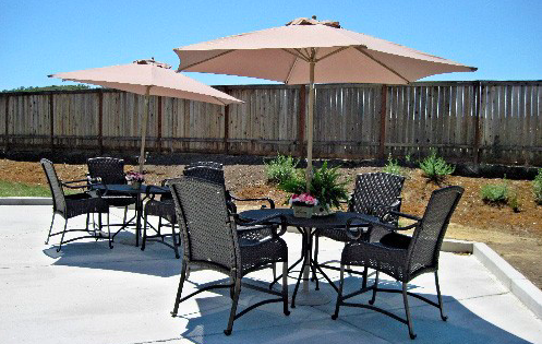 A cozy outdoor patio setup featuring chairs and umbrellas, perfect for enjoying a sunny day.