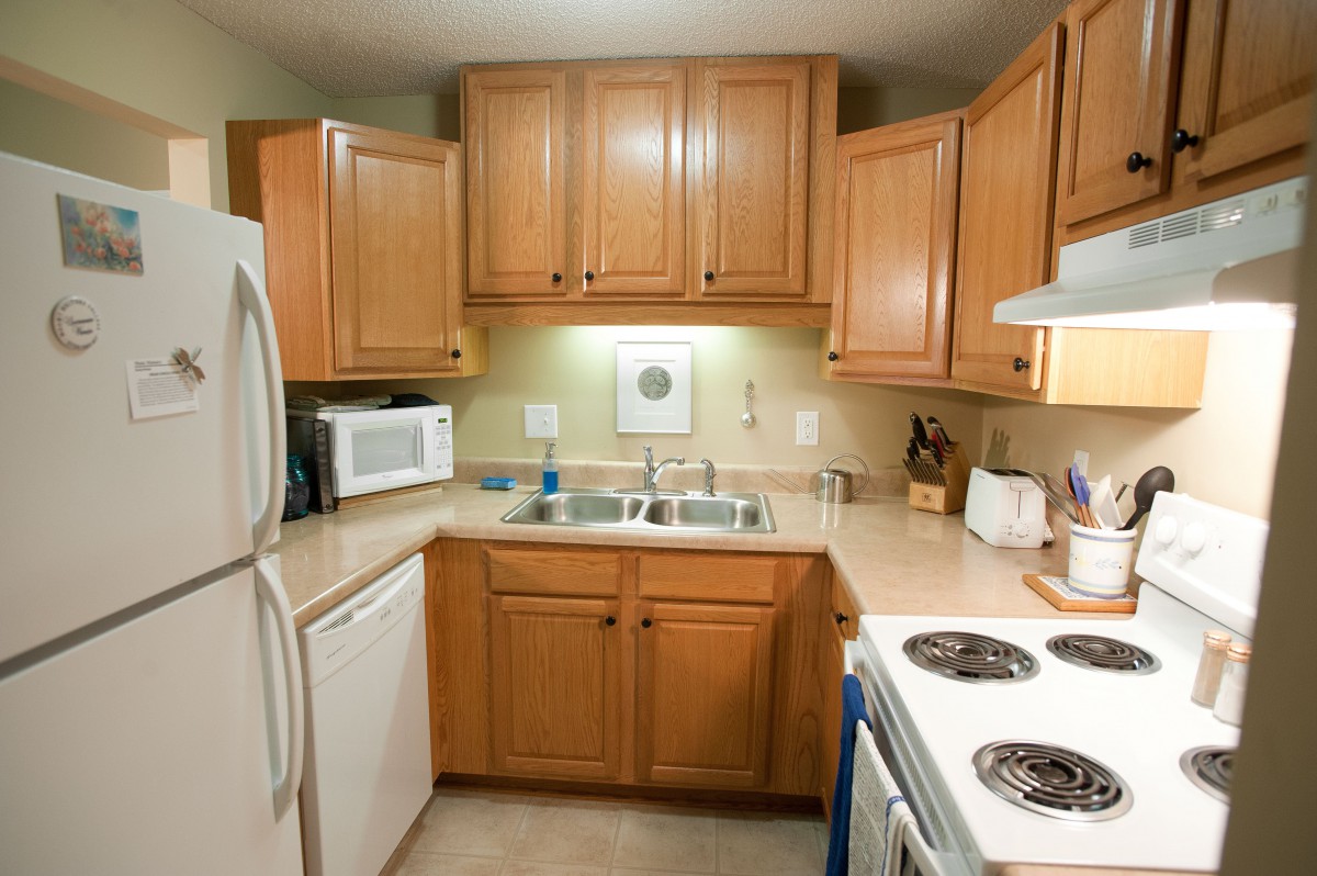 A cozy kitchen with wooden cabinets and various appliances.