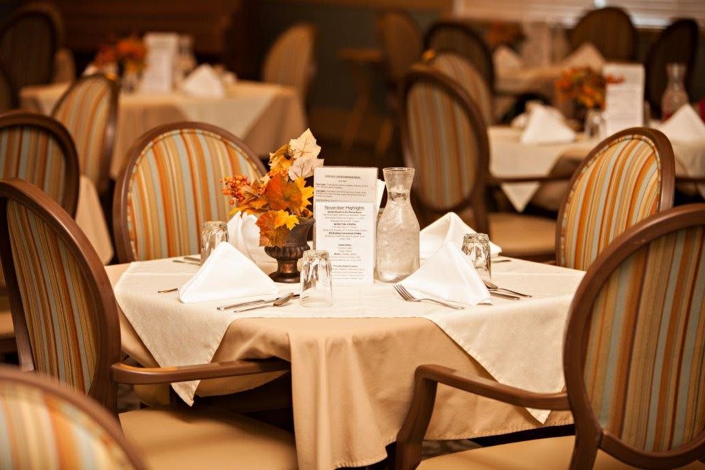 A neatly set dining table in a formal restaurant setting.