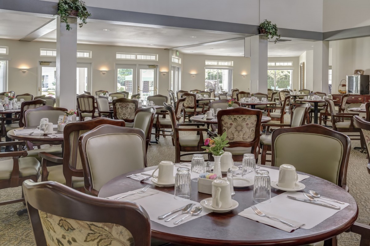 An elegant dining area with neatly set tables and chairs, ready for guests.
