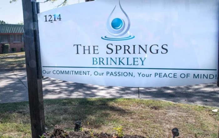 A sign for The Springs at Brinkley, featuring their slogan 'Our Commitment, Our Passion, Your Peace.'