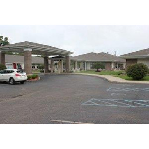 A view of the entrance to a commercial building with a parking area.