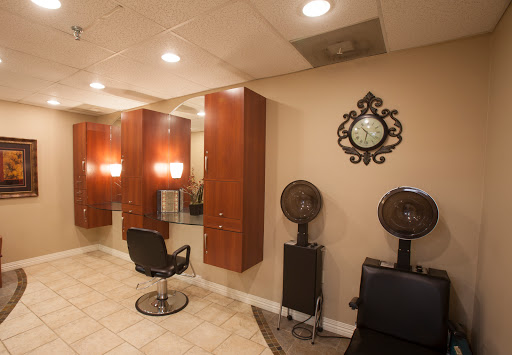 A cozy hair salon featuring stylish barber chairs, mirrors, and ambient lighting.