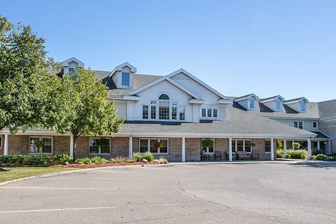A suburban residential building with a landscaped front and clear blue sky.