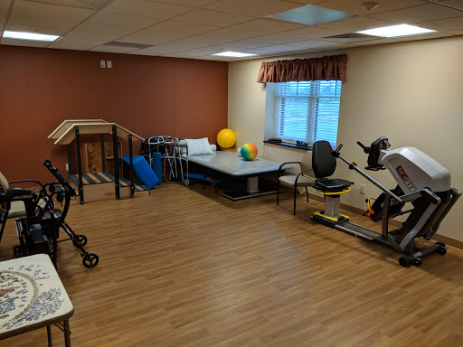 A spacious rehabilitation and exercise room equipped with various fitness tools for physical therapy.