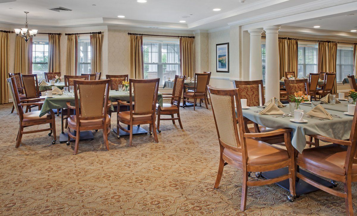 A well-appointed dining room with elegant tables and chairs, featuring large windows and tasteful decor.