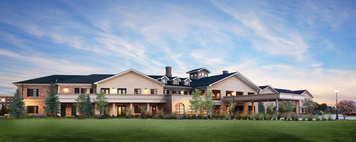 A large, luxurious mansion set against a blue sky with surrounding greenery.
