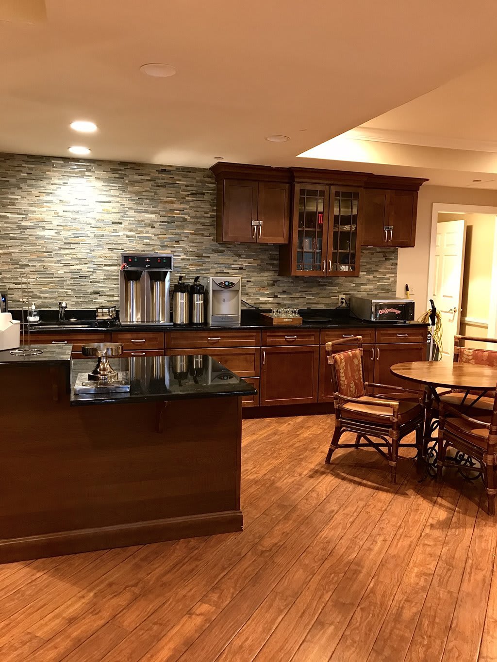 A modern kitchen with wooden cabinets, granite countertops, and a cozy dining area.