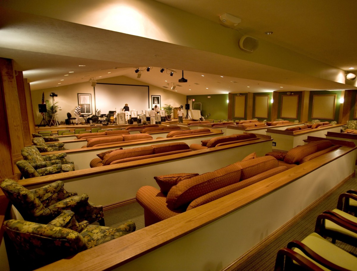 An auditorium with comfortable couch seating and a stage at the front.