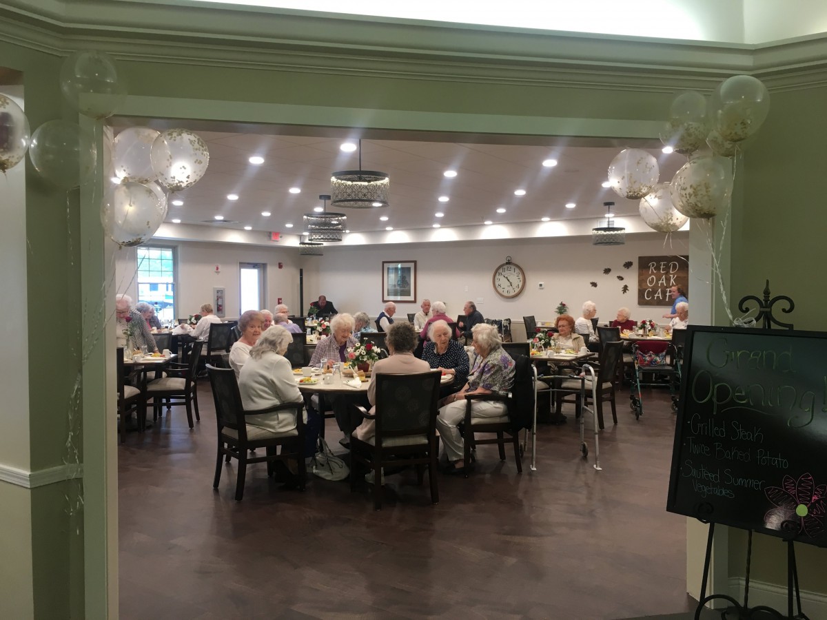 A group of seniors gathered in a dining room at a community center.