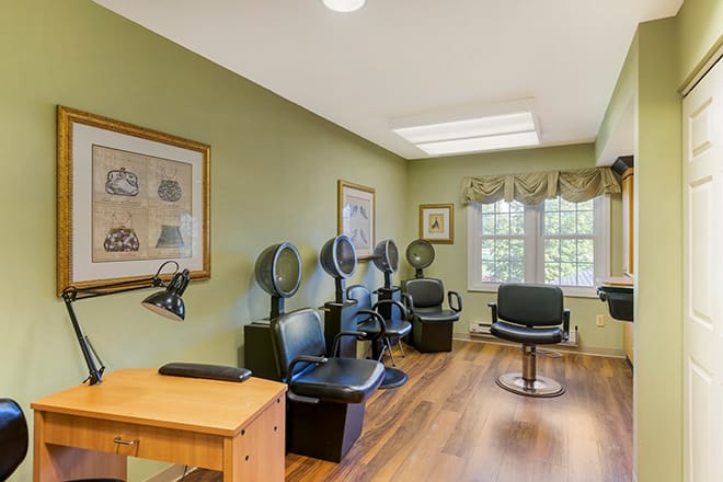 A cozy salon interior with multiple hair dryer stations and comfortable seating.