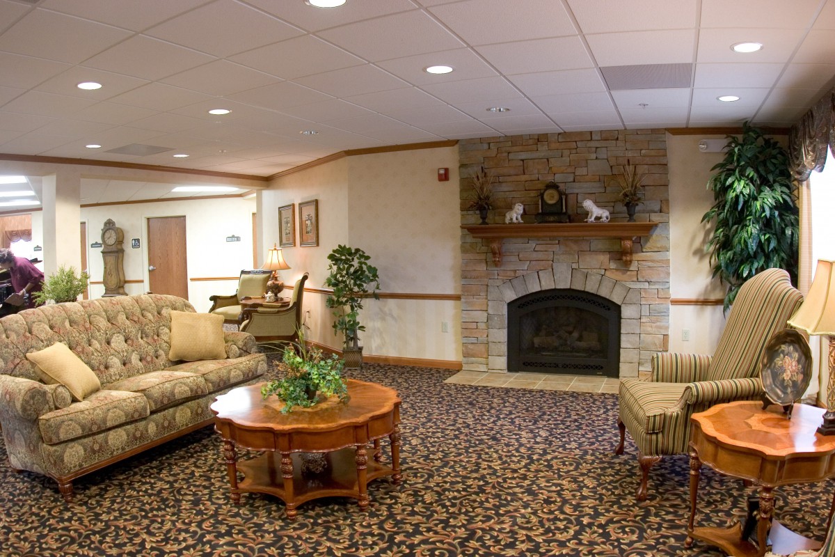 A cozy living room with a fireplace, sofa, and coffee table, featuring elegant decor.