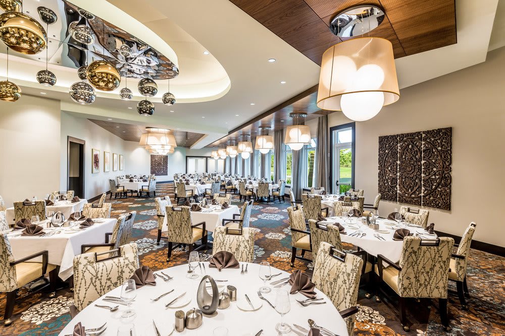 An elegantly designed restaurant dining area with neatly arranged tables and stylish lighting.