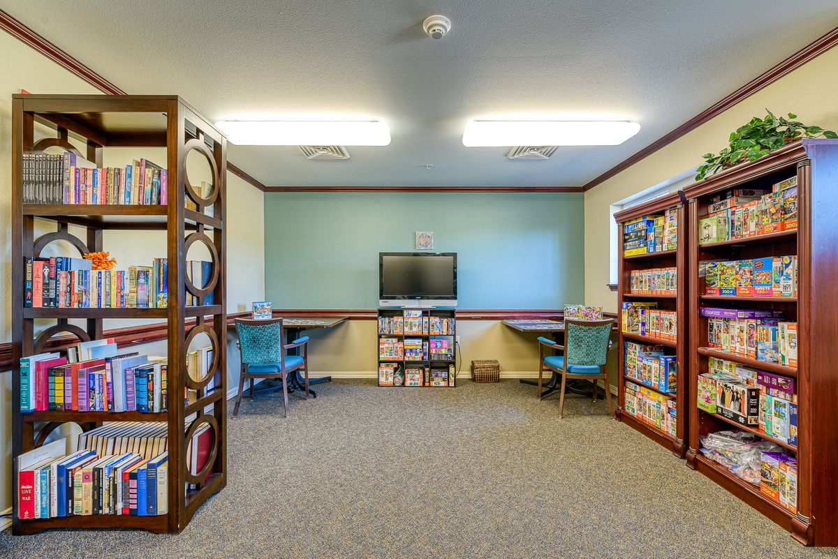 A quiet library space with bookshelves, a TV, and seating for reading.