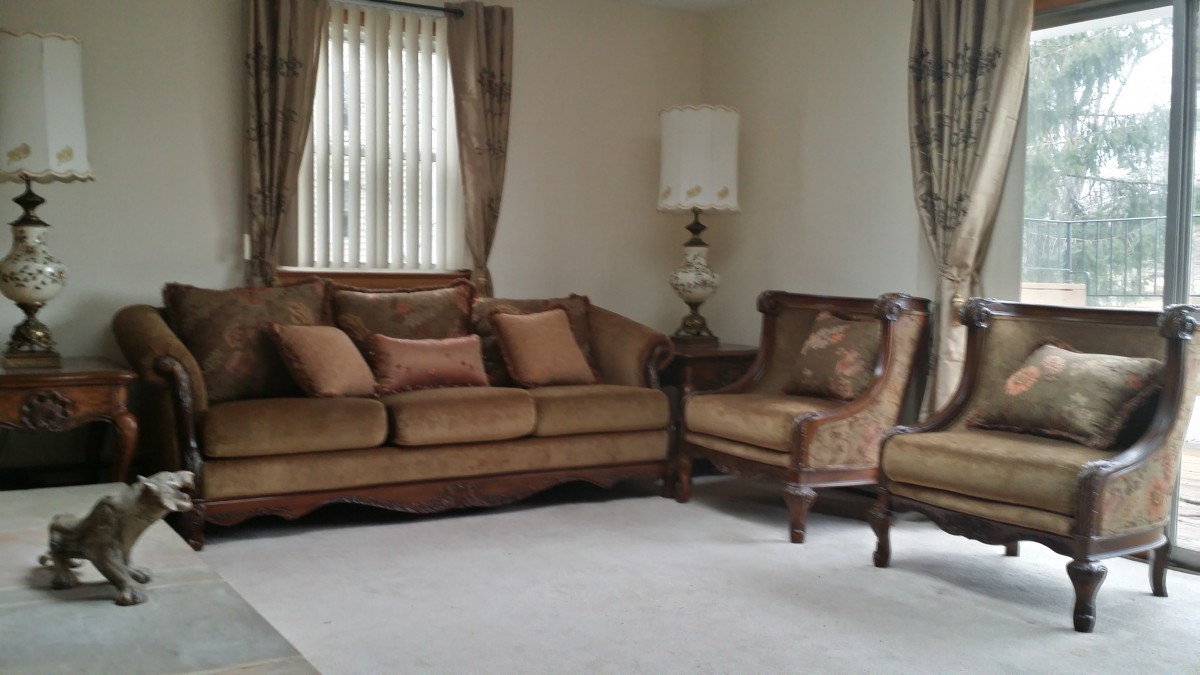 A cozy living room with a brown sofa, matching armchair, and lamp.