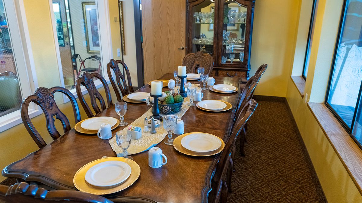 A formal dining table set with dishes and candles, ready for a meal.