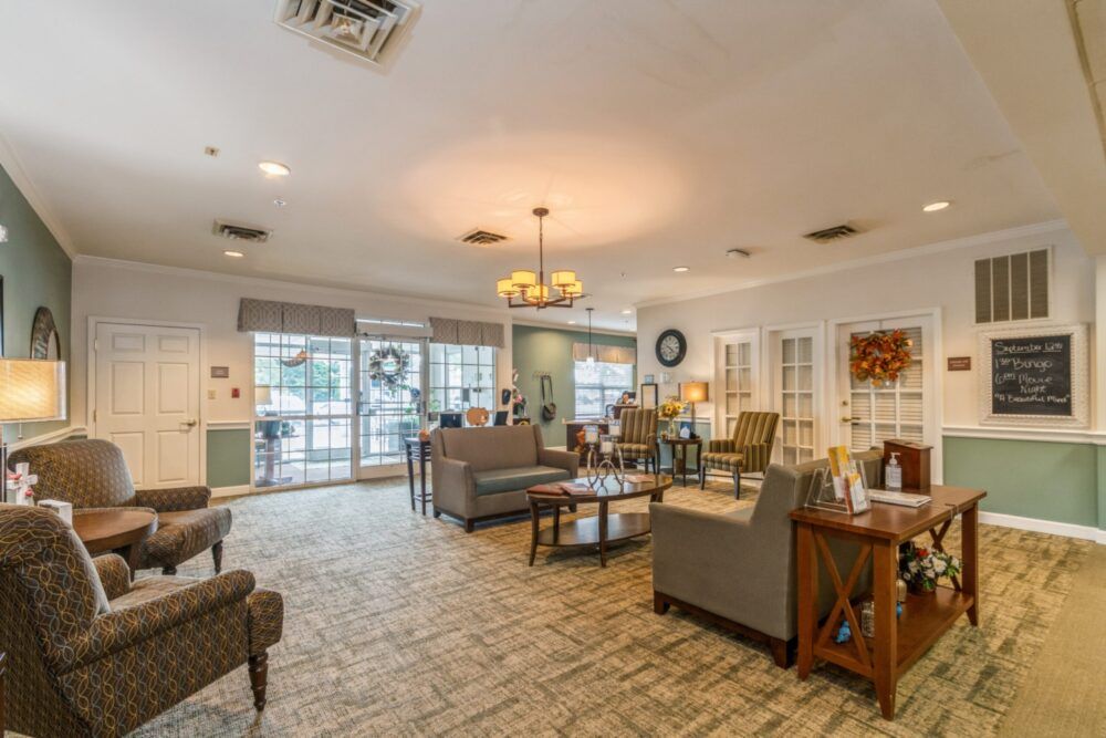 A cozy and well-lit living room featuring comfortable seating, a chandelier, and tasteful decor.