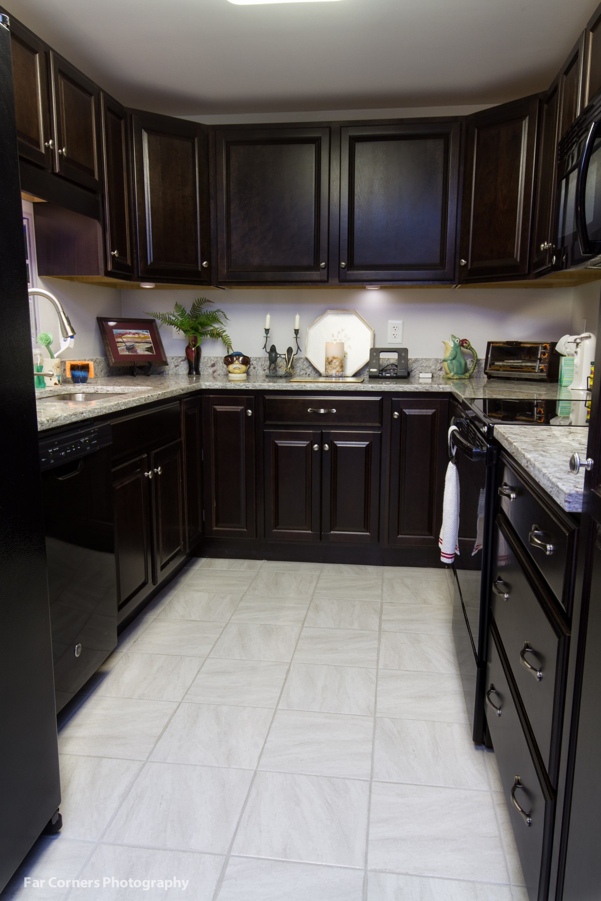 A modern kitchen featuring dark wood cabinets and sleek appliances.
