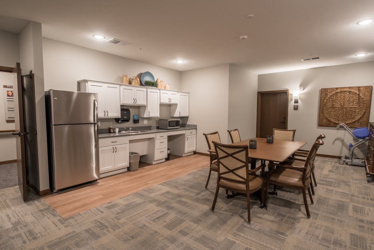 A modern kitchen and dining area with stainless steel appliances and a wooden dining table.