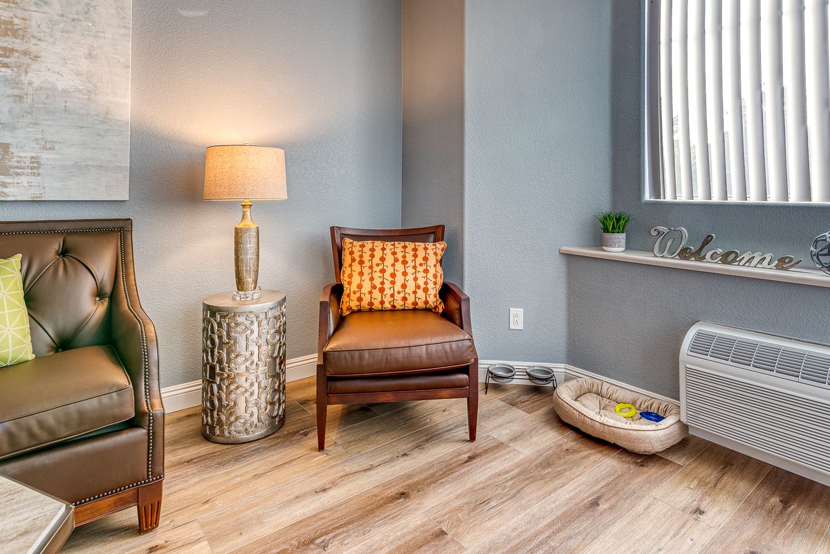 A cozy corner featuring a stylish chair and lamp, accented by modern decor and wood flooring.