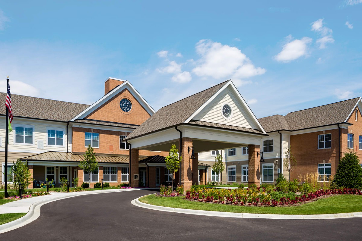 A modern residential facility with a landscaped driveway and welcoming entrance.