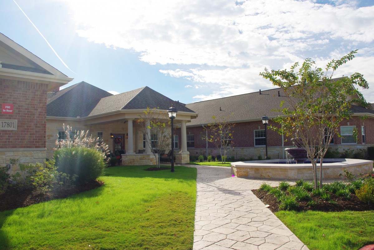 A modern house with a well-manicured lawn and pathway under a sunny sky.