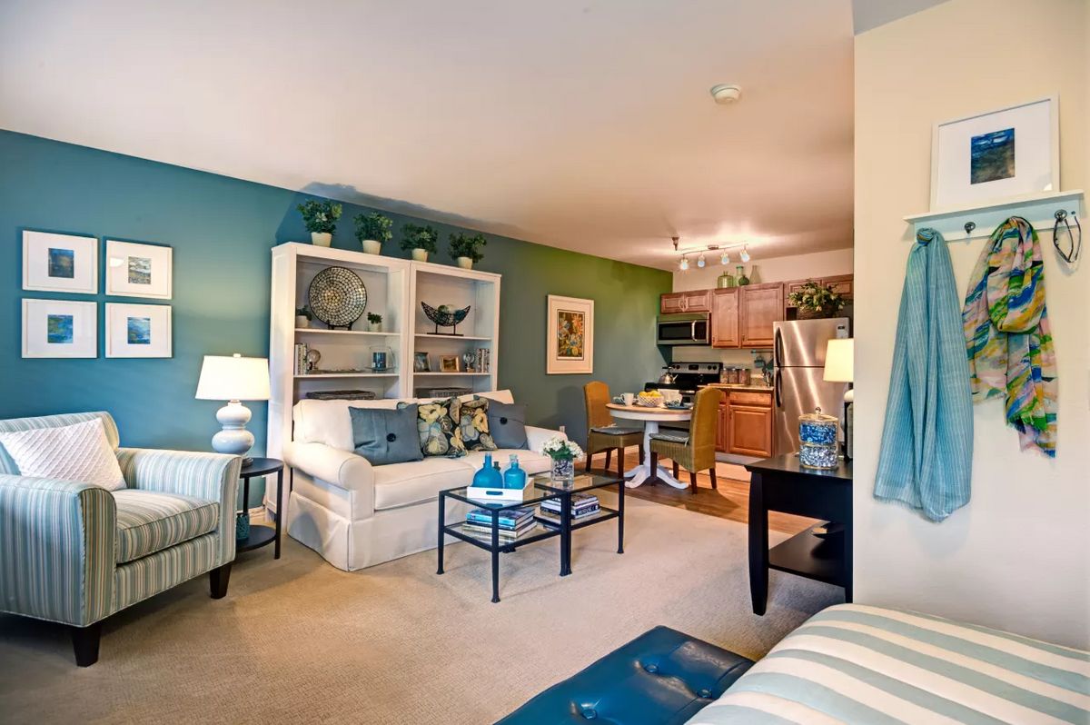Cozy living room with a connected dining area and kitchen, featuring comfortable furniture and stylish decor.