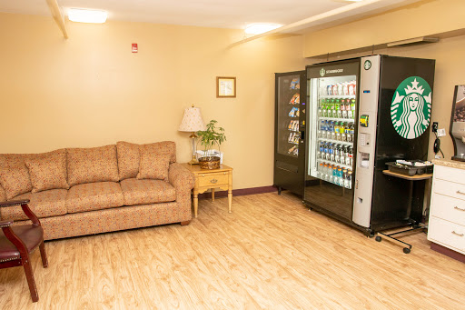 A cozy relaxation area featuring a sofa and a vending machine stocked with drinks.