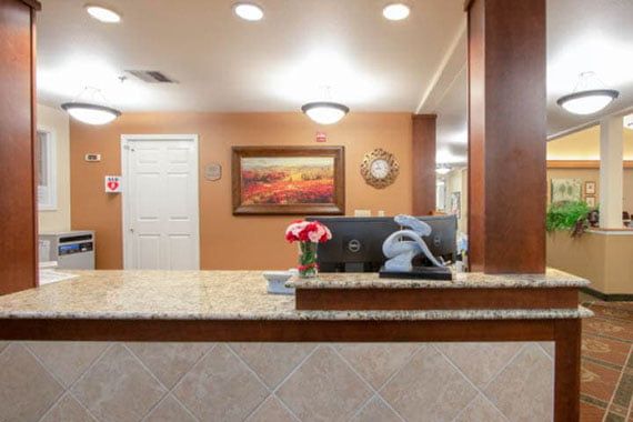 A reception desk with decorative elements, including a flower vase and artwork on the wall.