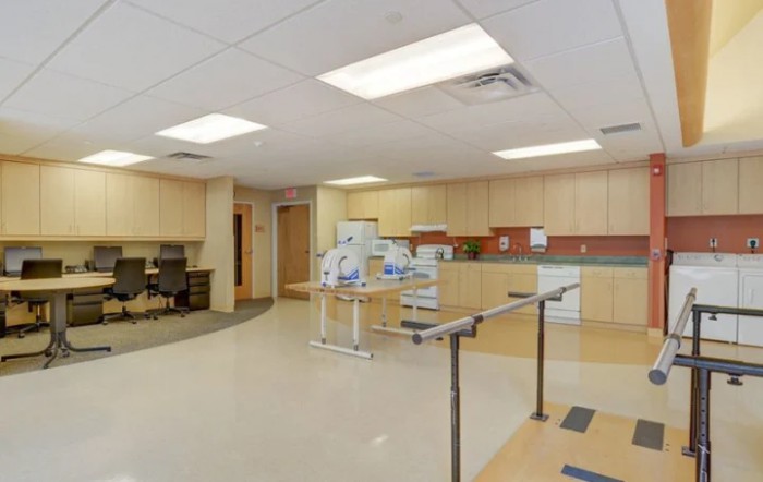 A rehabilitation room equipped with parallel bars and exercise equipment.