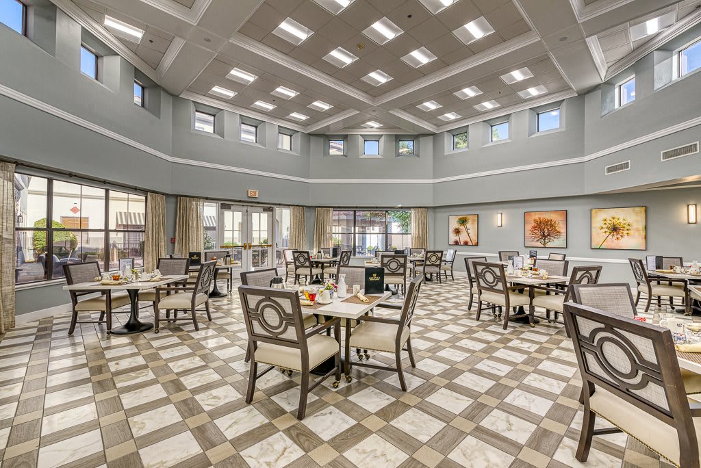 A spacious and elegant dining room with neatly arranged tables and chairs.