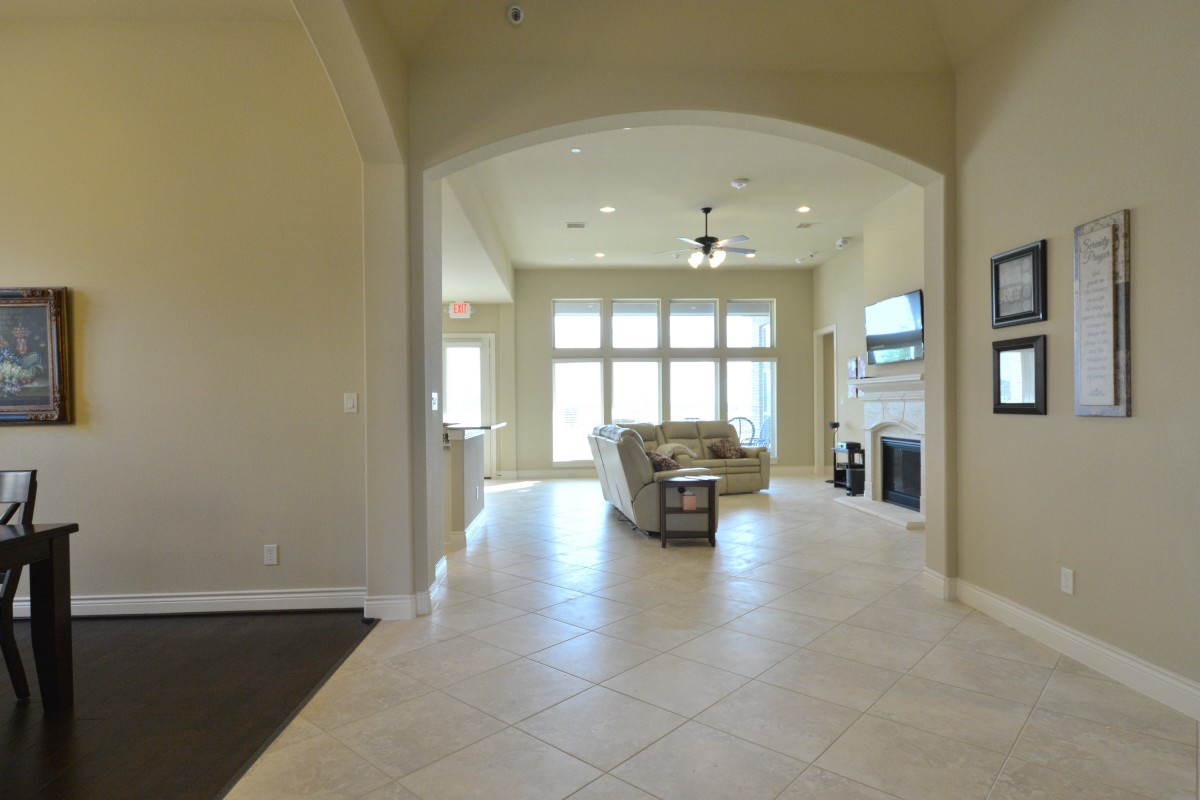 A modern living room with large windows, a comfortable sofa, and a sleek fireplace.