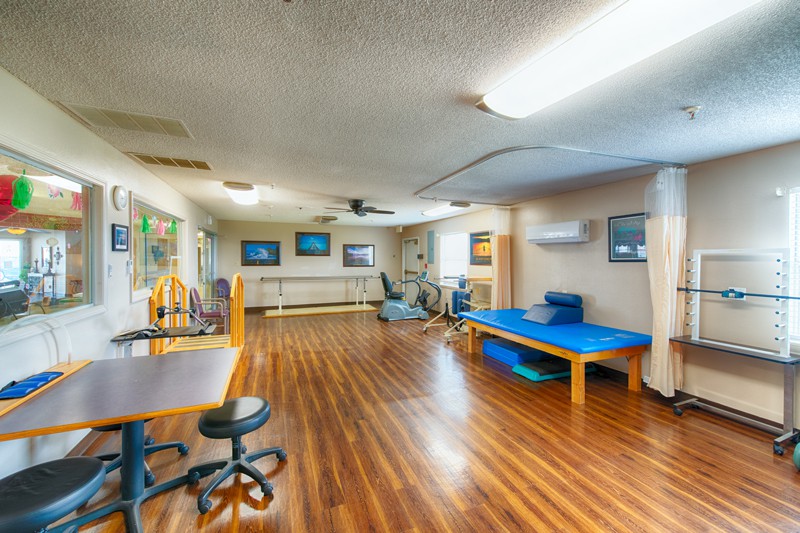 A spacious rehabilitation center equipped with exercise and therapy equipment.