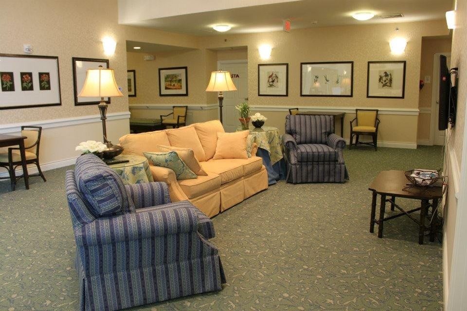 A cozy living room with sofas, chairs, and lamps arranged in a well-decorated interior.