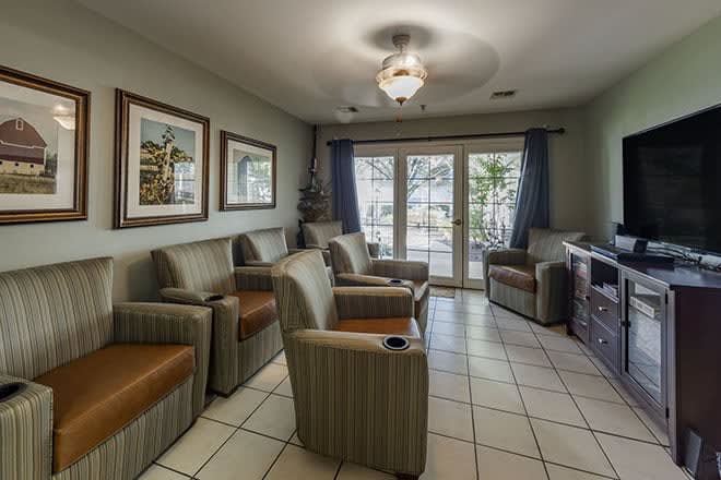 A cozy waiting room with comfortable chairs and artwork on the walls.