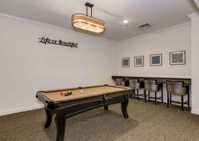 A stylish game room featuring a pool table and contemporary decor.