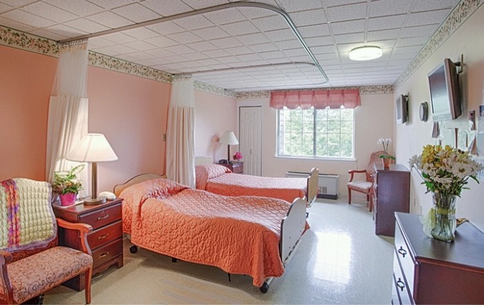 A cozy bedroom with two beds and pink decor.