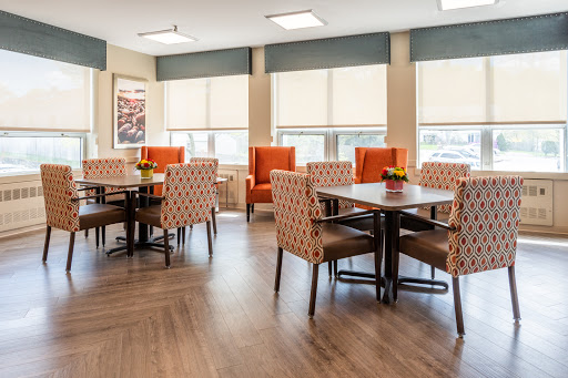 A cozy dining area featuring modern furniture with colorful chairs and natural light.
