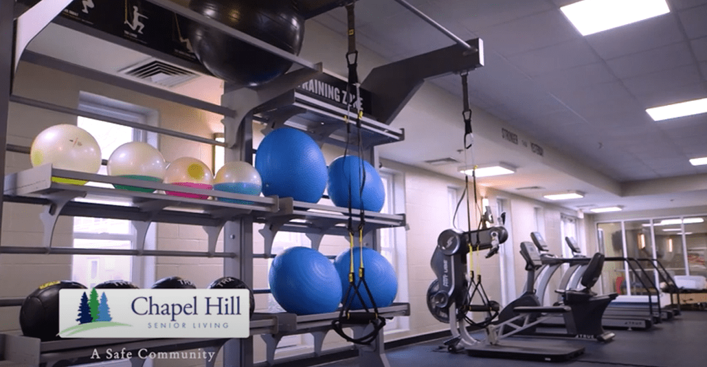 A modern gym with various fitness equipment including stability balls and weights.
