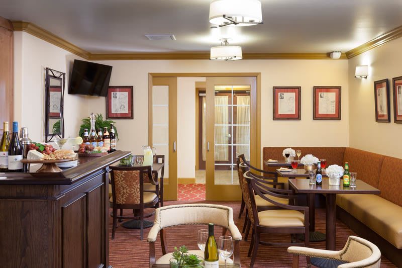 A cozy restaurant dining room with arranged tables and chairs, ambient lighting, and decorative elements.