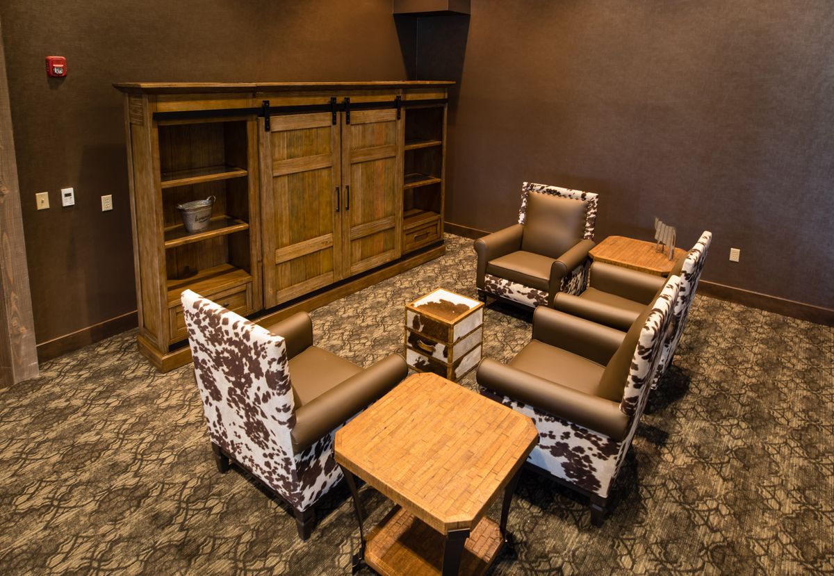 A cozy lounge area featuring armchairs and a wooden table.
