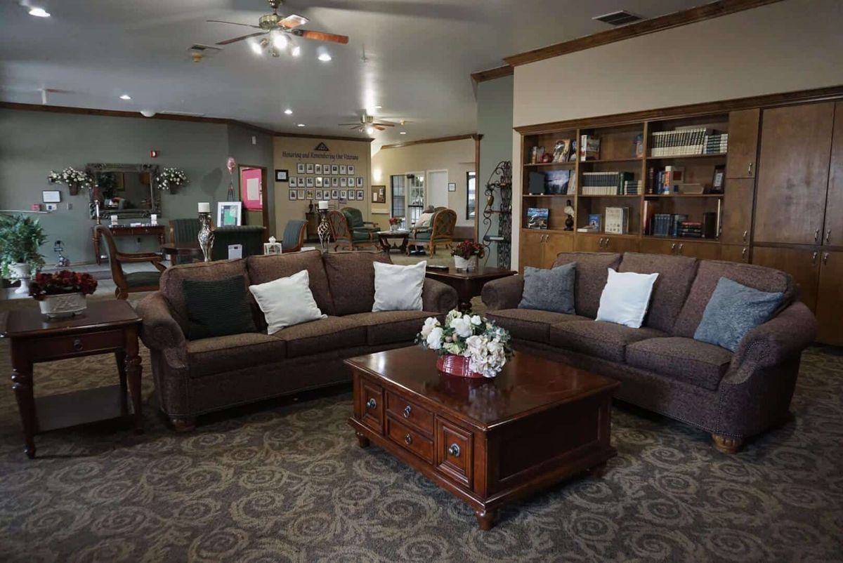 A cozy living room with sofas, a coffee table, and bookshelves.