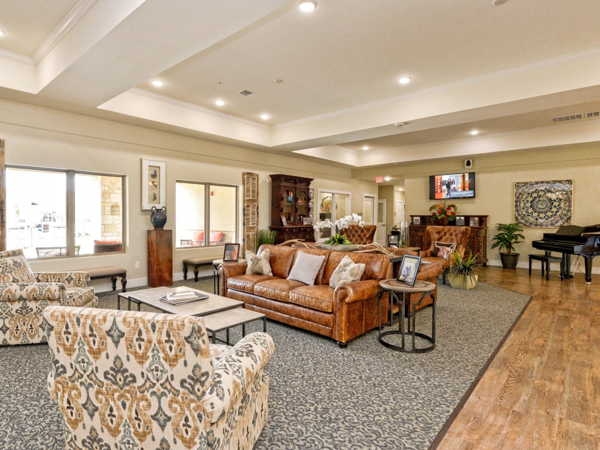 A spacious and elegantly decorated living room with comfortable seating, warm lighting, and tasteful decor.