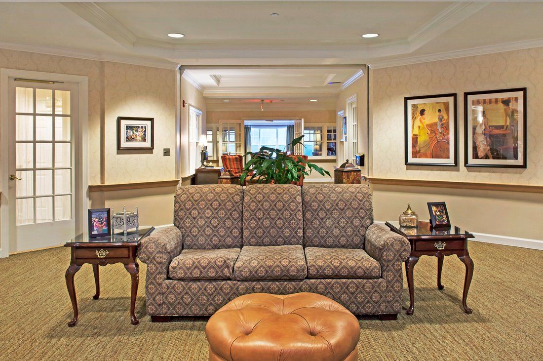 A cozy living room with a patterned sofa, framed artwork, and decorative tables.