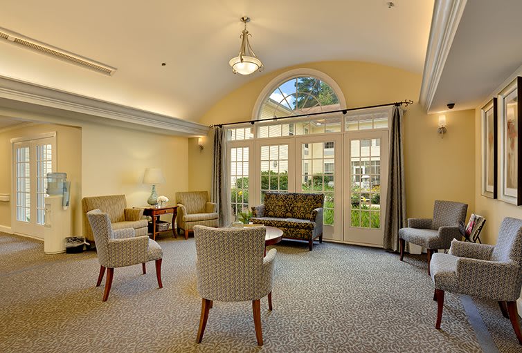 A spacious and well-lit living room with comfortable seating and large windows.