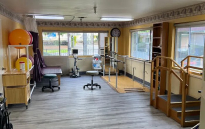 A physical therapy room equipped with exercise equipment and rehabilitation tools.