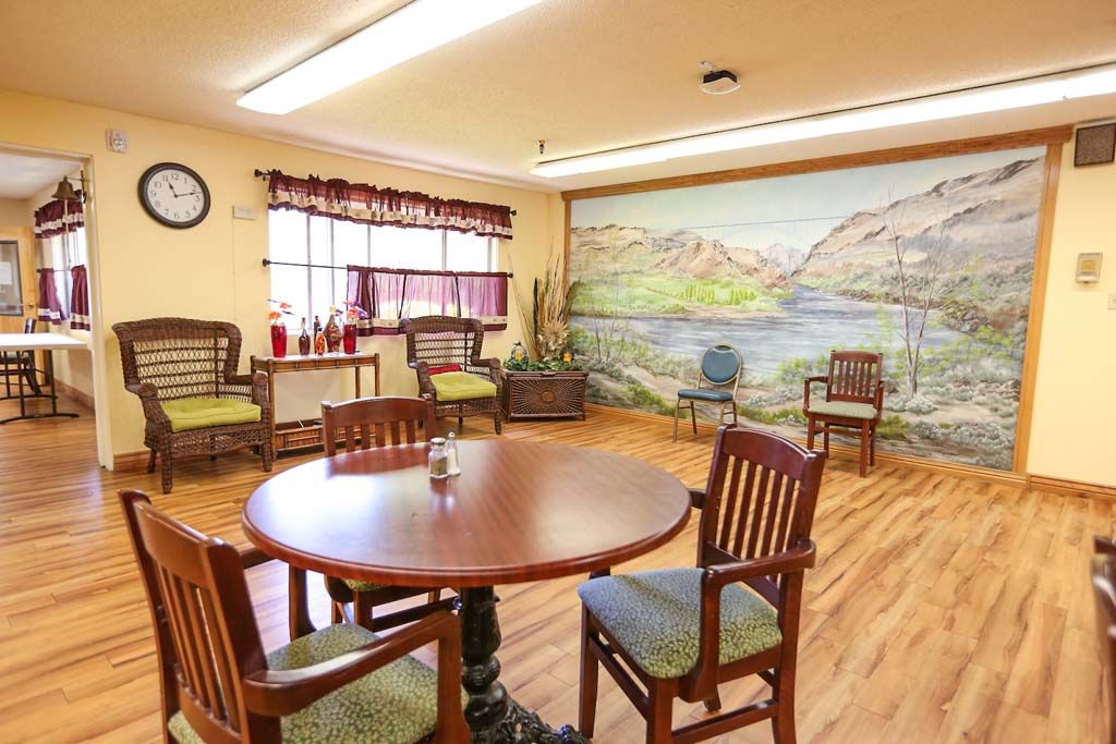 A cozy dining area with wooden furniture and a scenic mural on the wall.