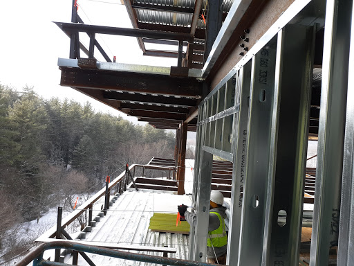 View of a construction site featuring multiple balconies on a winter day.