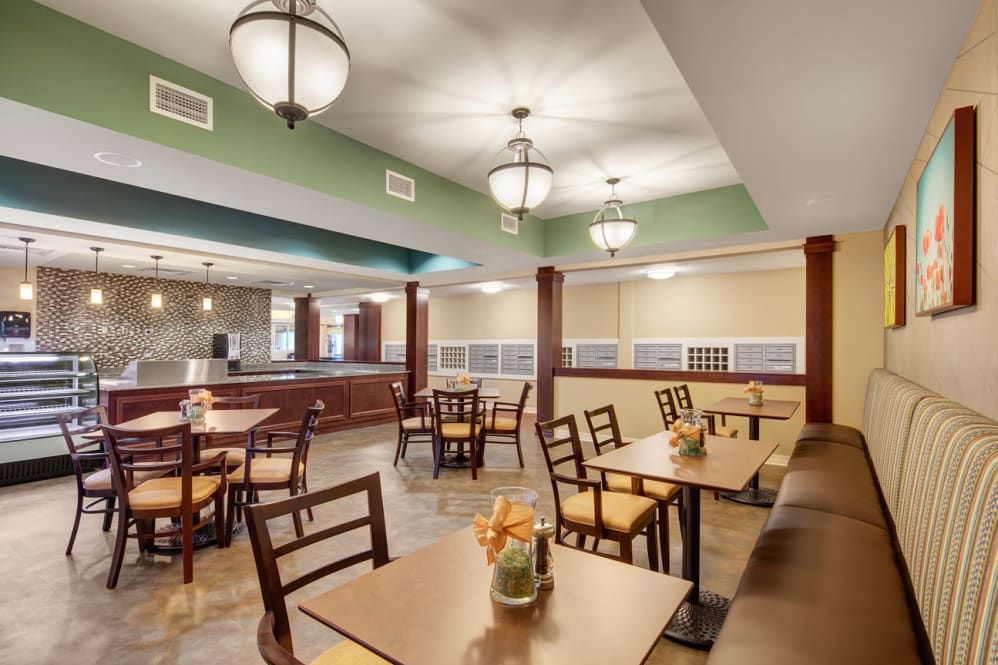 A cozy dining area with tables and chairs, featuring elegant lighting and decor.