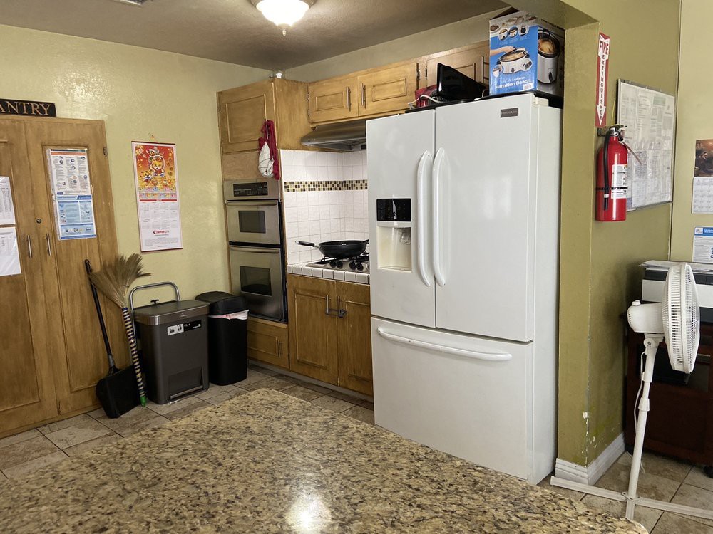 A kitchen with wooden cabinets and modern appliances, including a refrigerator and oven.